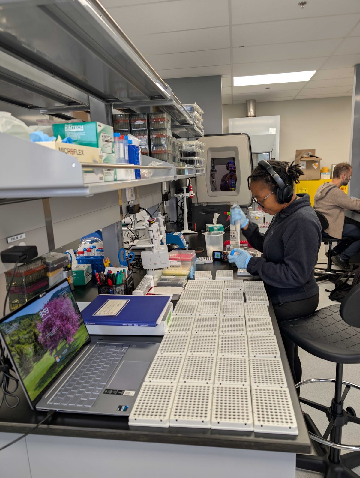 A lab member pipetting samples into rows of 96 well plates in the new wet lab
